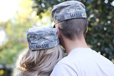 a man and woman are wearing hats with the words massie on them in front of some trees