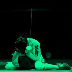 a person sitting on the ground with a tennis racket in their hand and headphones to his ear