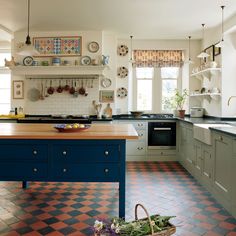 a kitchen with an island in the middle and lots of plates on the wall above it