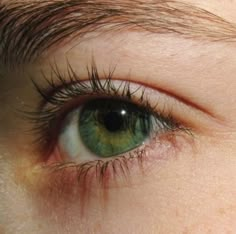 a close up of a person's green eye