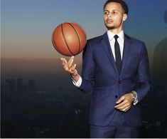 a man in a suit and tie holding a basketball