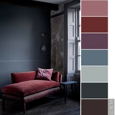 a red couch sitting in front of a window next to a wall with gray walls