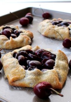 cherry pastries on a baking sheet ready to go into the oven with cherries