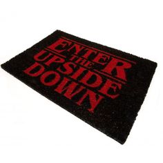 a black and red door mat with the words enter the upside down in red on it