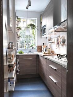 a narrow kitchen with wooden cabinets and blue flooring