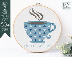 a cross - stitch coffee cup with a hot beverage in it