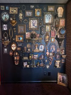 a wall with many framed pictures on it