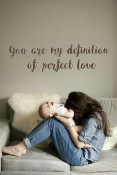 a woman sitting on top of a couch holding a baby in her lap and the words you are my definition of perfect love