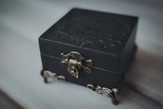 a small black box sitting on top of a white table next to a pair of scissors