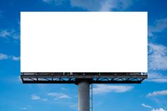 an empty billboard on top of a tall pole with blue sky and clouds in the background