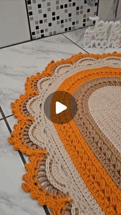 an orange and white rug sitting on top of a tiled floor