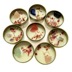 six small bowls filled with different types of candies on top of a white surface