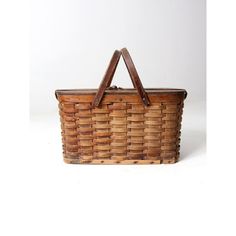 an old woven basket with wooden handles on a white background, it is used as a picnic basket