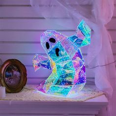 a lighted ghost sitting on top of a table next to a mirror