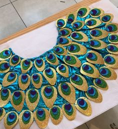 a large blue and green peacock feathered design on a table