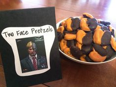 two face pretzels are in a bowl next to a card