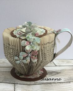 an origami coffee cup with flowers on it