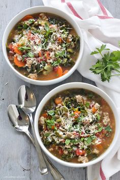 two bowls of soup with meat, vegetables and parmesan cheese