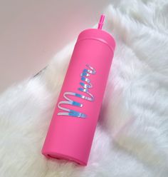 a pink water bottle sitting on top of a white fur covered floor