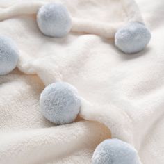 three blue balls are laying on a white blanket