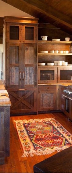 a kitchen with wooden cabinets and an area rug