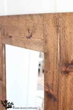 a wooden mirror frame with wood grain on it