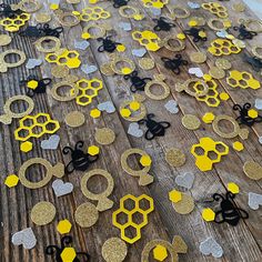 some yellow and black paper cut outs on a wooden surface with scissors in the shape of hexagons