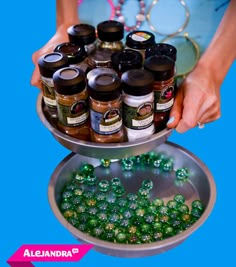 a person holding a tray filled with lots of green beads