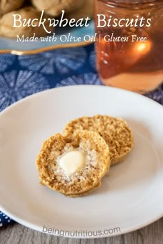 two cookies on a white plate next to a jar of tea