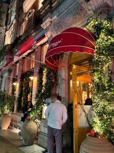 a man standing in front of a building with christmas decorations on the outside and inside