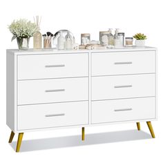 a white dresser topped with lots of drawers and vases on top of each drawer