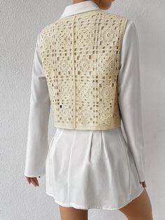 the back of a woman's jacket with crochet on it and white shorts