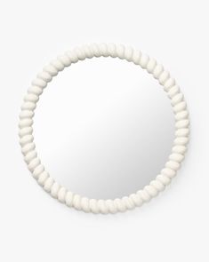 a round mirror with white beads around it