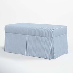 a blue and white striped bench with pleated skirting on the bottom, in front of a white background