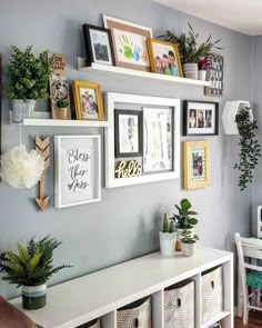 a wall with many pictures and plants on it's sides, along with other decorations