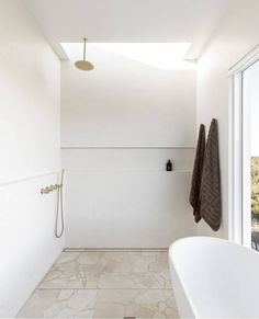 a bathroom with white walls and tile flooring next to a bathtub in the corner