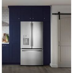 a stainless steel refrigerator in a kitchen with blue cabinets