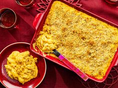 a casserole dish is on a red plate next to two bowls of food