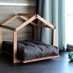 a dog bed that is made out of wood and has a house on the top