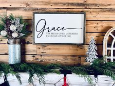 a christmas mantle with ornaments and a sign that reads grace the fresh green, embellished family and love of god