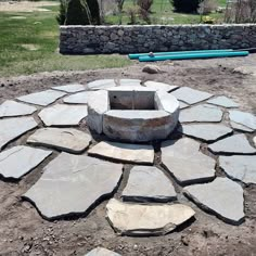 a stone fire pit in the middle of a field