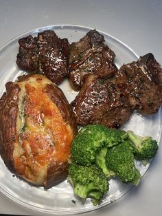 a white plate topped with meat and broccoli