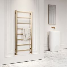 a white bathroom with a gold towel rack