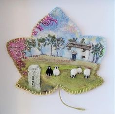 sheep are grazing on the grass in front of a house with trees and flowers painted on it