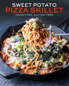 a skillet filled with pasta and olives