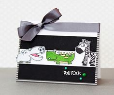 a card with an alligator and crocodile stickers on it, tied to a ribbon