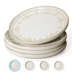 four white plates with gold trim around the edges and three smaller ones on each side