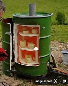 a man in red gloves working on an outdoor stove