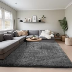 a living room filled with furniture and a large rug on top of a hard wood floor