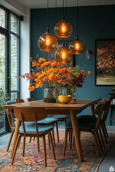 a dining room table surrounded by chairs and vases with flowers on it in front of large windows